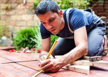 Man with Tools in Backyard Building a Greenhouse