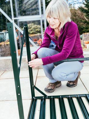 Woman Assembling Pre-Fab Backyard Greenhouse